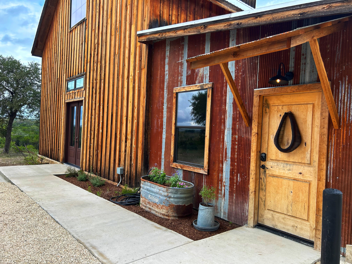 Image of exterior entrance to luxury hotel room in barn on texas ranch