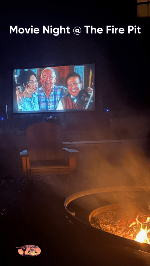 image of outdoor theater playing a movie with a firepit and adirondak chair