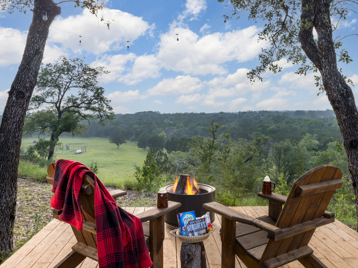 Image of two adirondak chairs and firepit on deck overlooking views in Texas Hill Country