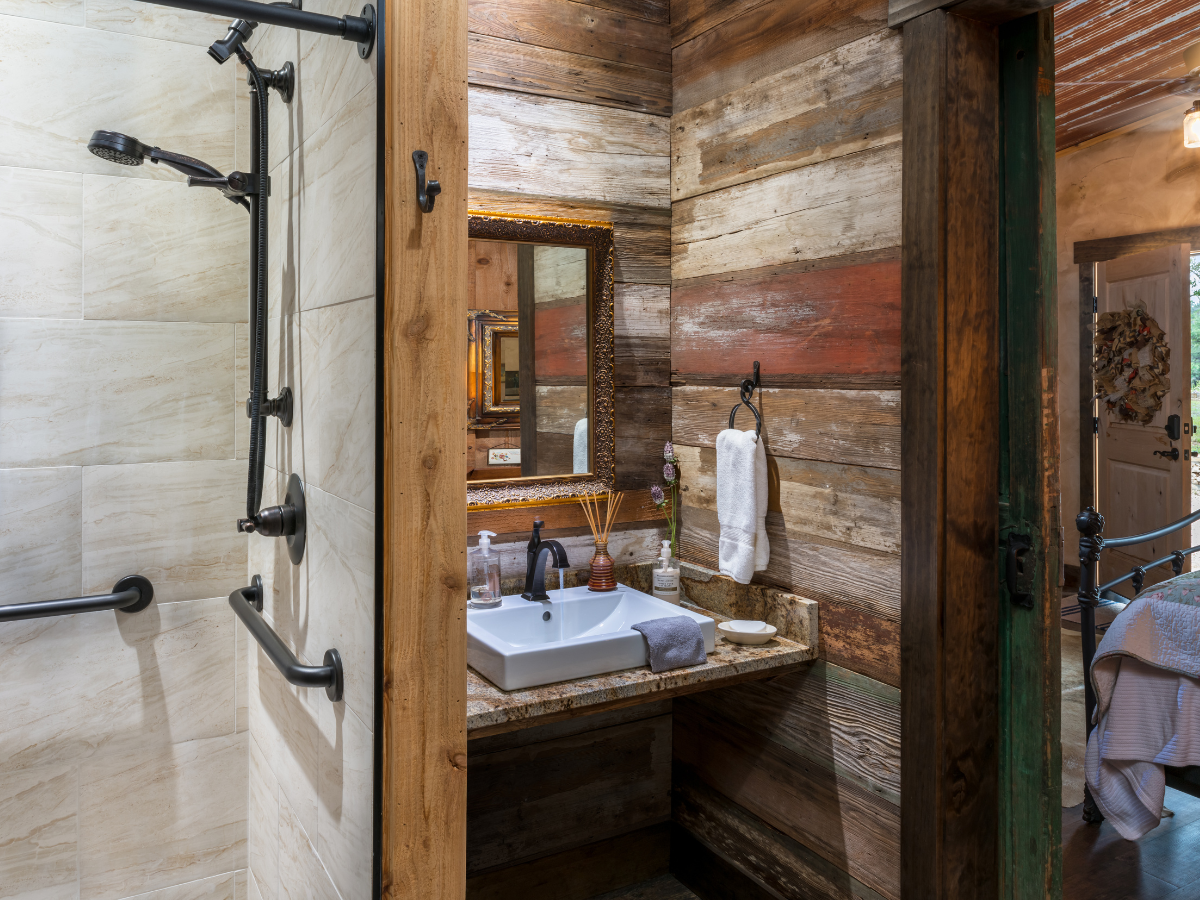 Image of bathroom with barnwood walls at wimberley lodging inn at sunset mill ranch