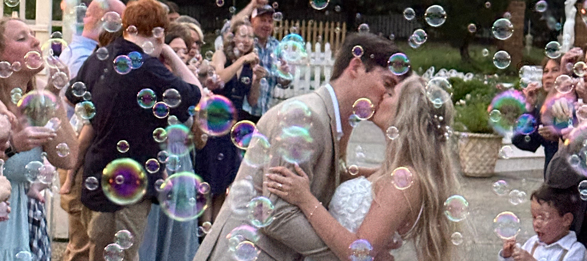 image of bride and groom kissing with bubbles around them