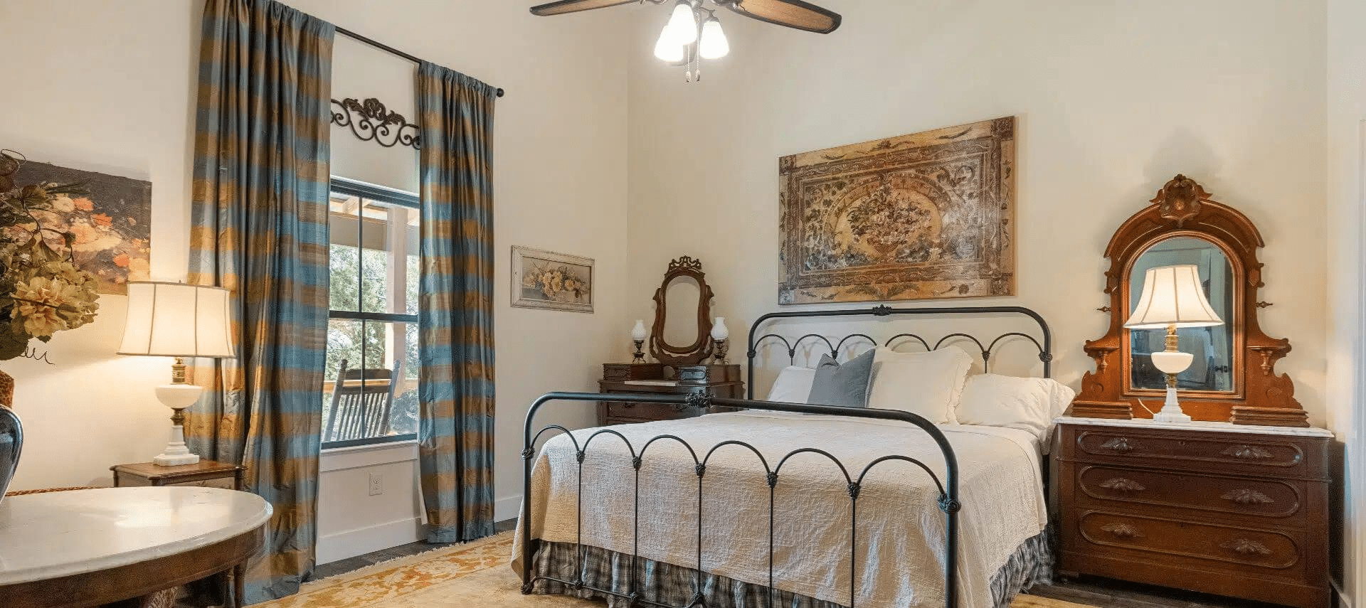 Image of Gorgeous accommodations (king bed, ceiling to floor drapers, and antique style furniture) in The Sunset Room at Inn at Sunset Mill Ranch in Texas Hill Country