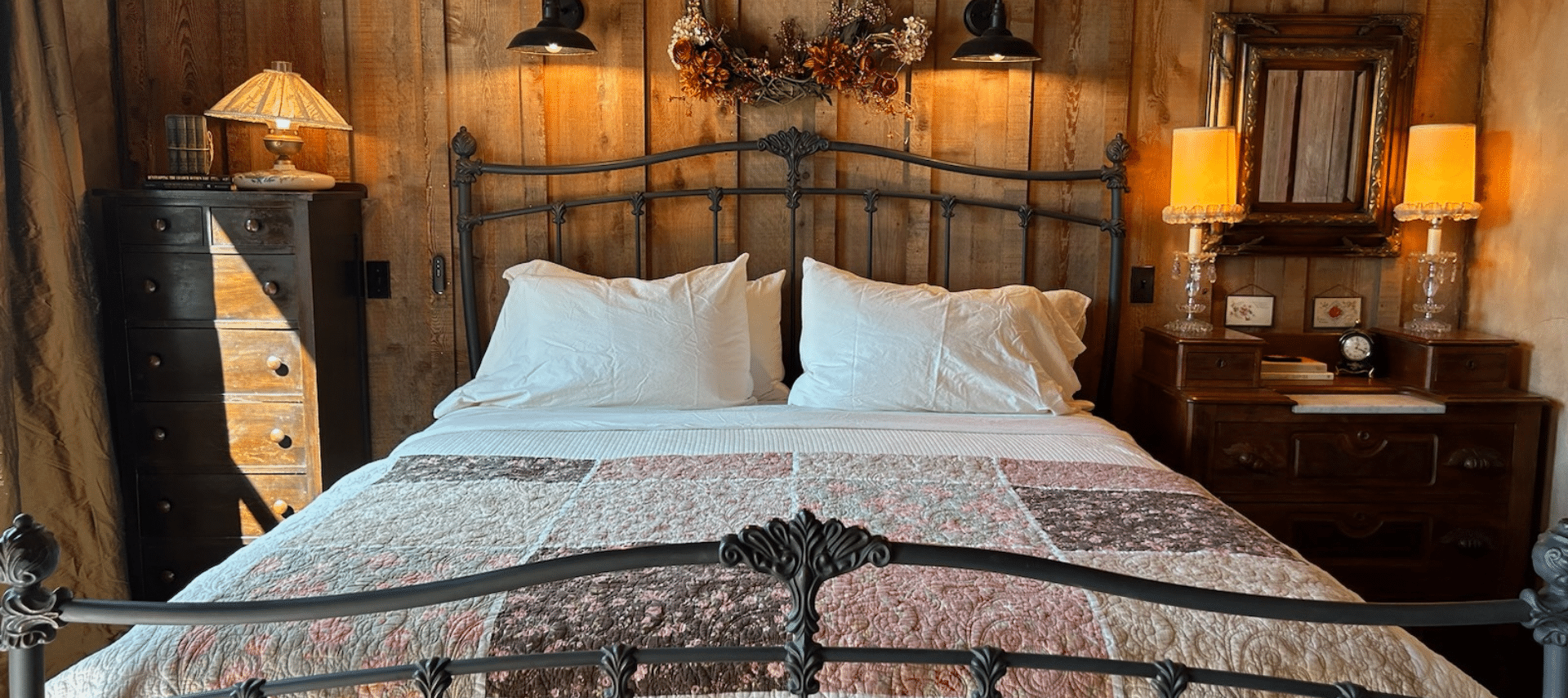 Image of King Bed against barnwood wall and beautiful quilt at foot of bed in The Granary Room accommodations at Inn at Sunset Mill Ranch in Wimberley Texas