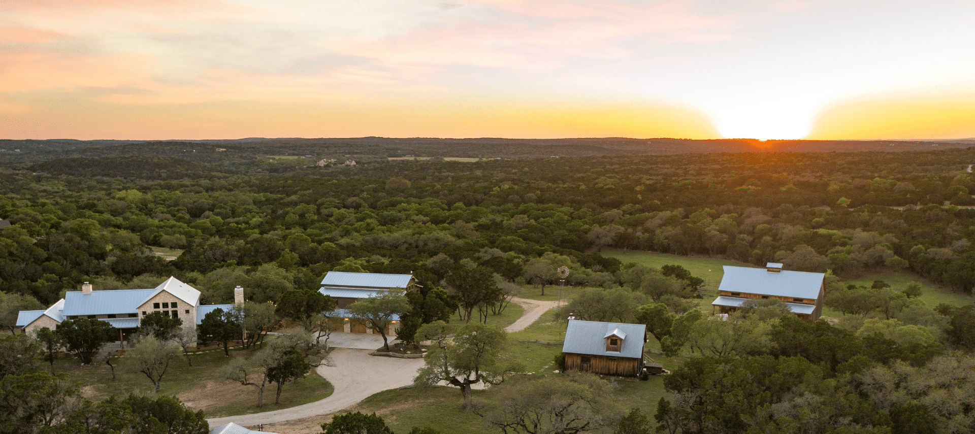 Image of 25 sprawling acres in Texas Hill Country overlooking a sunset from grounds at Inn at Sunset Mill Ranch.