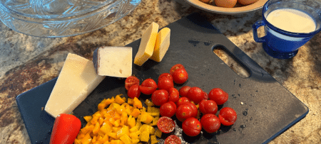 Image of fresh tomato, pepper, and cheese on cutting board showcasing Wimberley restaurants food prep