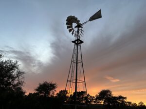 Image of weather vain with gorgeous sunset in the background at Inn at Sunset Mill Ranch in Wimberley, Texas.